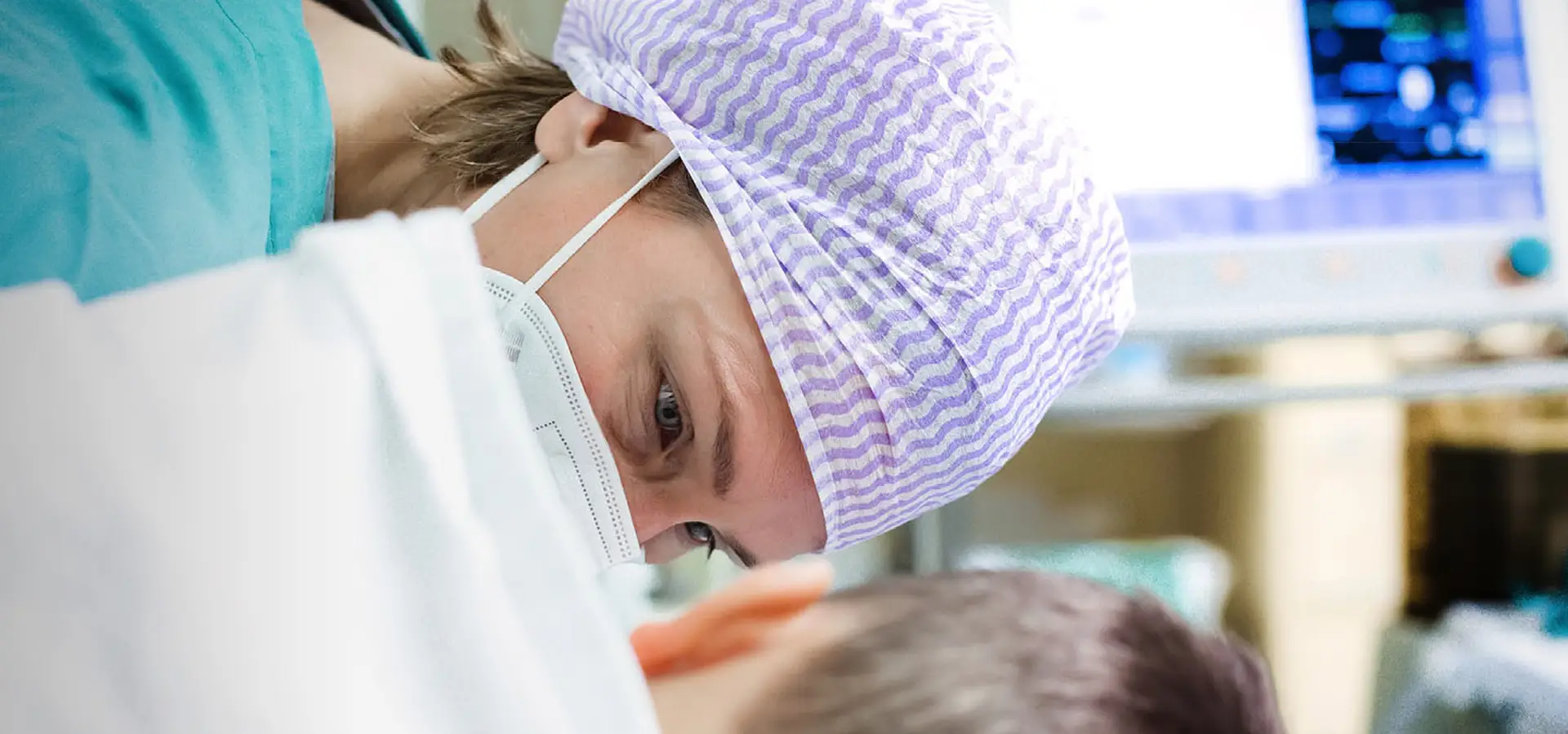 Weibliche Ärztin mit Maske untersucht einen Patienten (Foto)