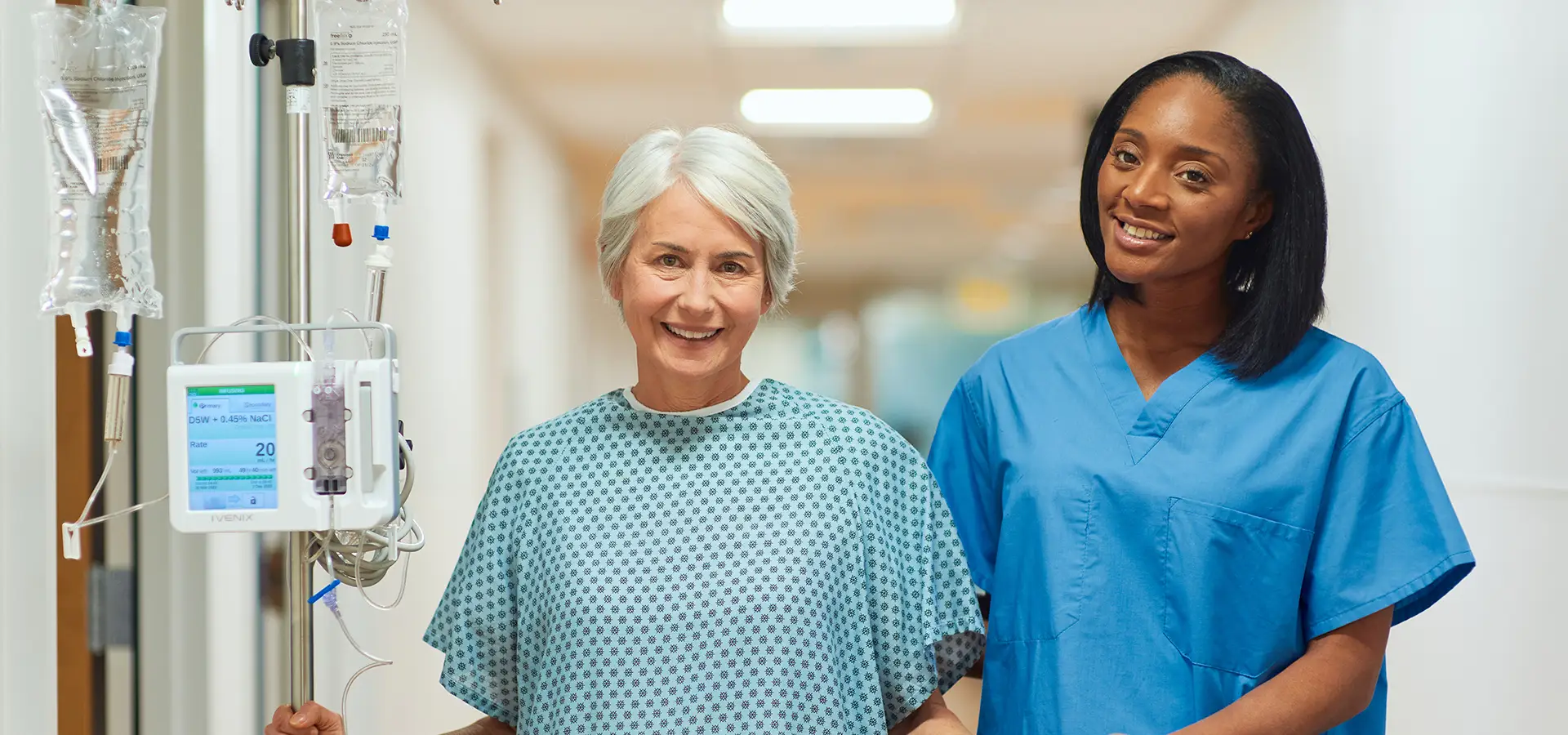 Nurse accompanies a patient with an infusion attached (Photo)