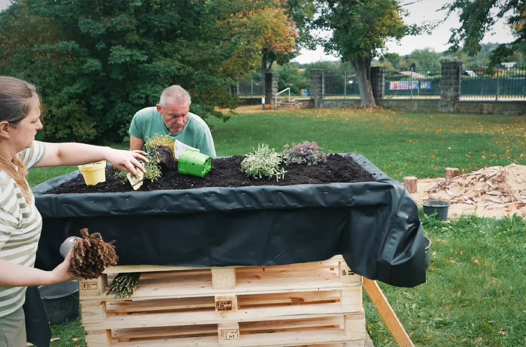 Two people are planting a raised garden bed (Photo)