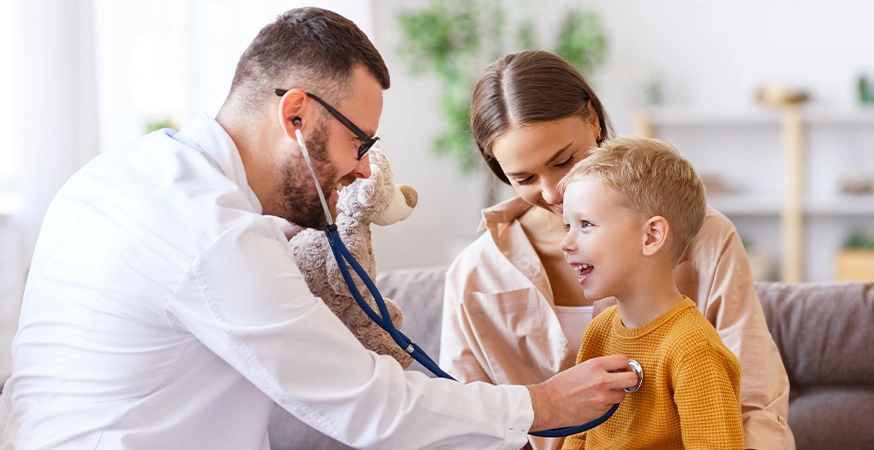 A doctor is examining a child; the mother is next to the child (Photo)