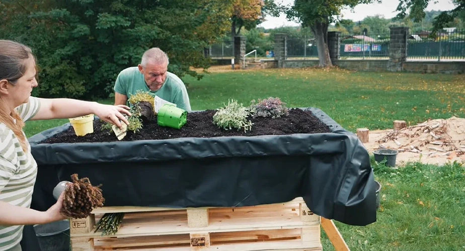 Two people are planting a raised garden bed (Photo)